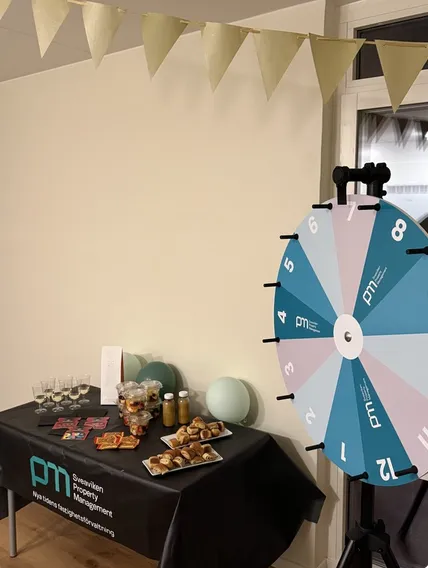 Eventbord med bubbel, fika och prishjul på ett visningsevent för Lilla Ängen